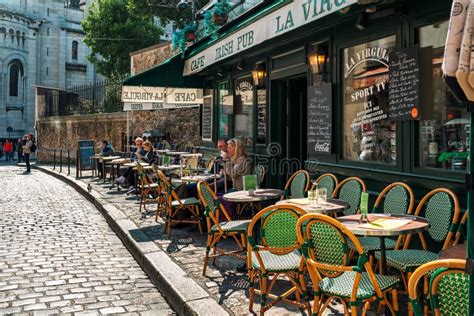 People Drinking Coffee In Typical Outdoor Coffee Shop In Paris France