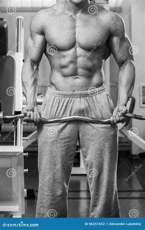 Hombre Muscular En El Gimnasio Que Realiza El Ejercicio Foto De Archivo