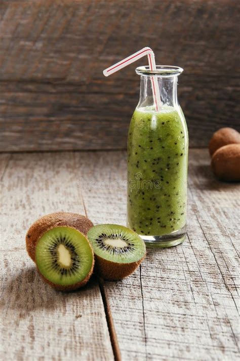 Bottle Of Kiwi Juice With Fresh Fruits On Wooden Table Stock Photo