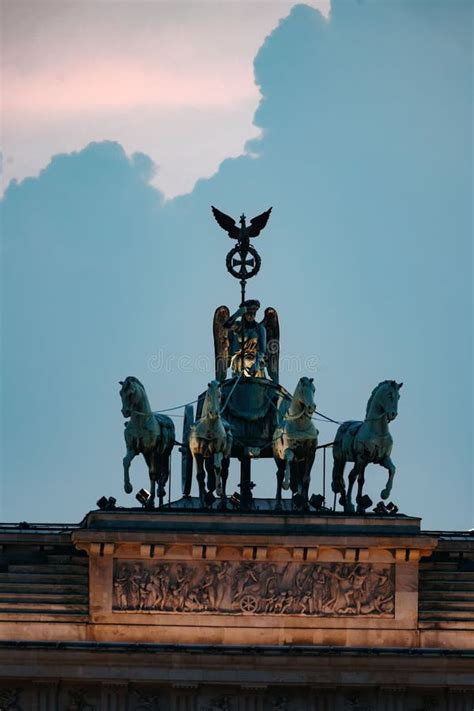 Vertical Shot Of The Brandenburg Gate Sculptures Under A Blue Sky In