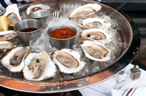 Oysters served raw with sauces — Stock Photo © razmarinka #28627501