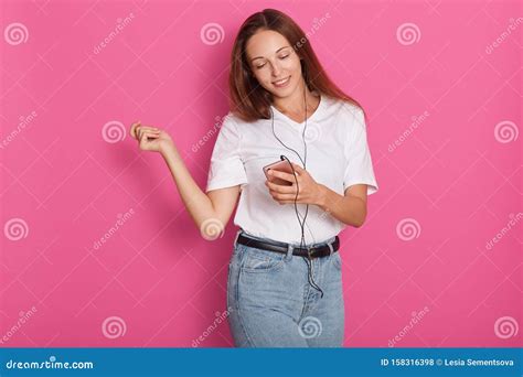 Woman Dancing With Earphones Listening To Music Via Smart Phone