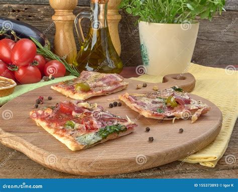 Pizza On Thin Dough With Slices Of Salami And Ham Olives And Tomatoes