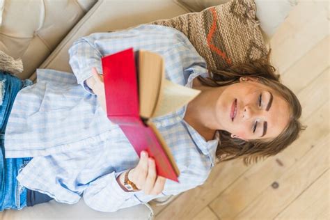 Free Photo High Angle View Of Woman Reading Book While Lying On Sofa