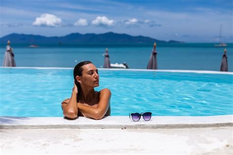 Caucasien femme bronzée peau de bronze brillant au bord de la piscine en bikini bleu à la