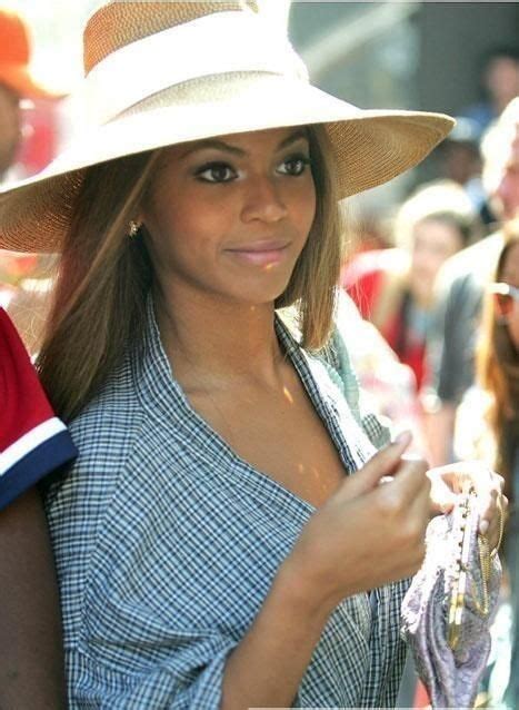 A Woman Wearing A Hat And Holding A Purse