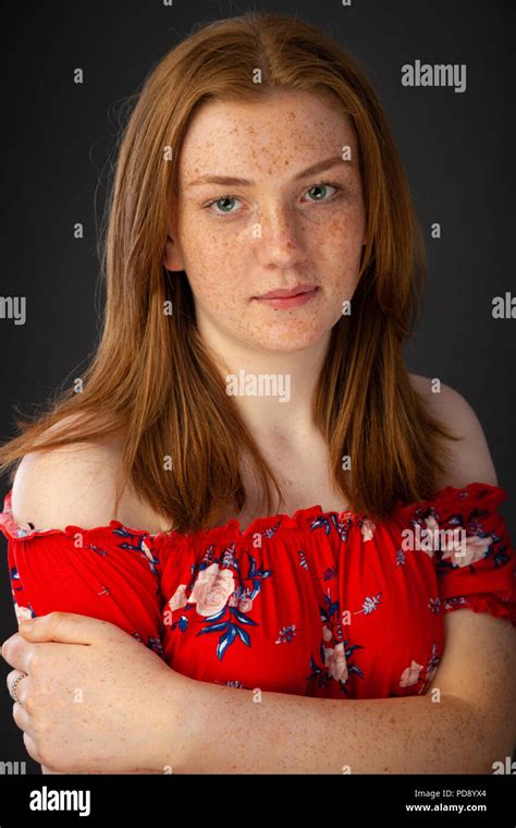 Portrait of a pretty teenage girl with red hair and freckles looking ...