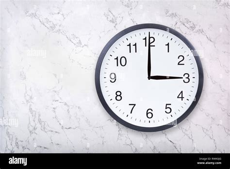 Wall clock show three o'clock on white marble texture. Office clock ...