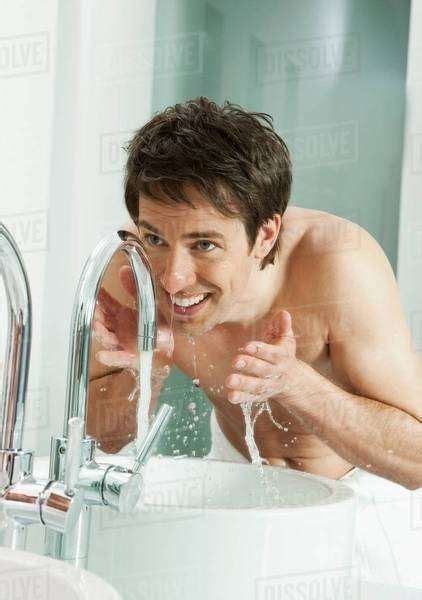 Man Washing His Face In Bathroom Stock Photo Dissolve