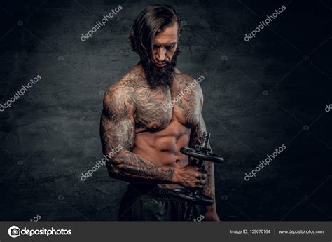 Man With Tattooed Body Holding Dumbbell Stock Photo Fxquadro