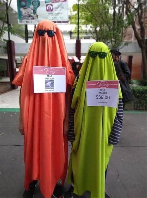 Two People Dressed In Costumes Standing Next To Each Other On The