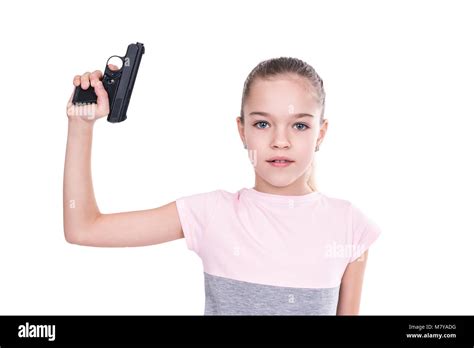 Young girl holding a gun in her hand pointing upwards, isolated on a ...