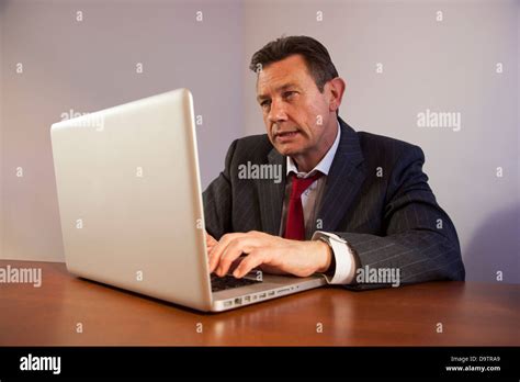 Mature Business Man At A Desk Using A Laptop Computer Stock Photo Alamy