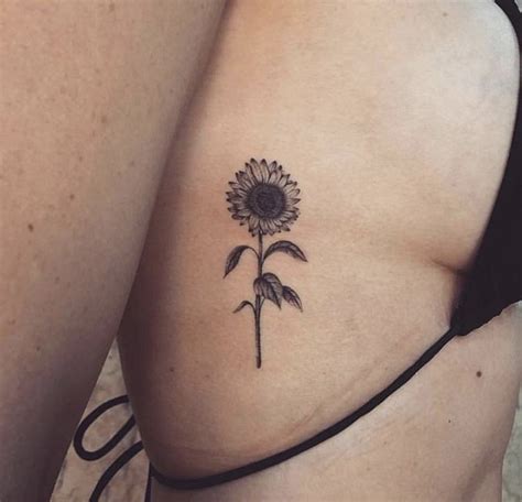 A Sunflower Tattoo On The Back Of A Woman S Left Side Ribcage