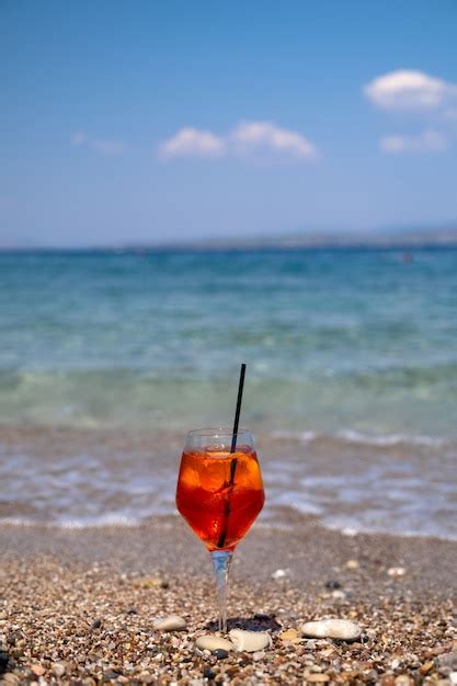 Copo De Aperol Spritz De Coquetel Na Areia Perto Do Mar Foto Premium