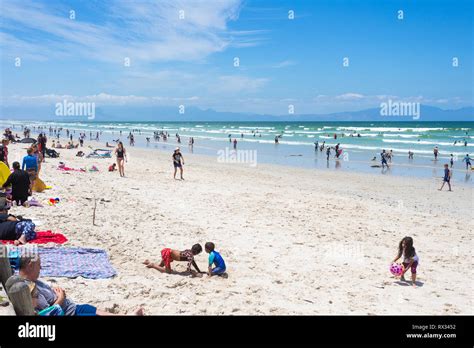 A Busy Beach Day With Crowds Of Beachgoers Enjoying Themselves On A Hot