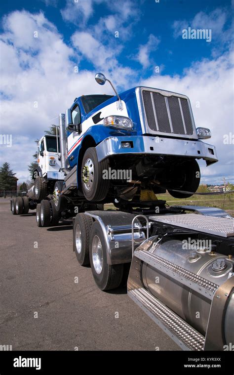 Un moderno poderoso semi big rig truck lleva otro camión articulado