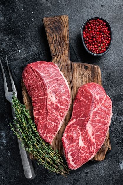 Premium Photo Fresh Raw Top Blade Or Flat Iron Beef Meat Steaks On A Butcher Cutting Board