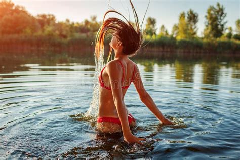 Young Woman In Bikini Jumping Out Of Water And Making Splash Summer