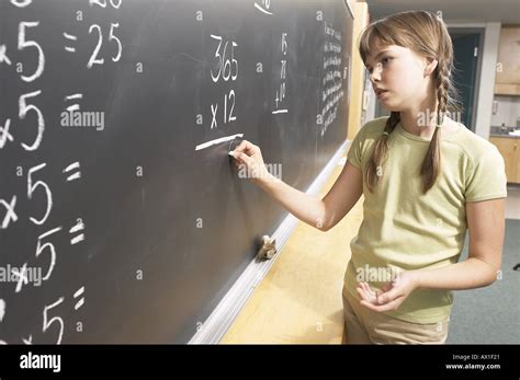 Little Girl Doing Math Equations On The Blackboard 1 Stock Photo Alamy