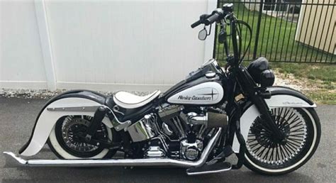 A White And Black Motorcycle Parked Next To A Fence