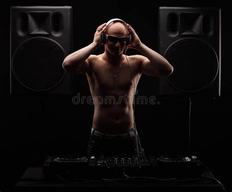 Bold Adult DJ Stands Near Mixer Between Two Big Speakers Half Naked