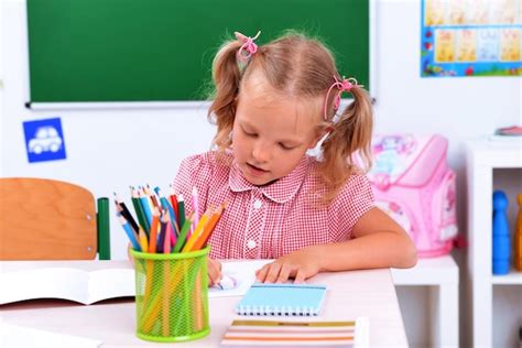 Ni A Dibujando En El Escritorio En El Aula Foto Premium