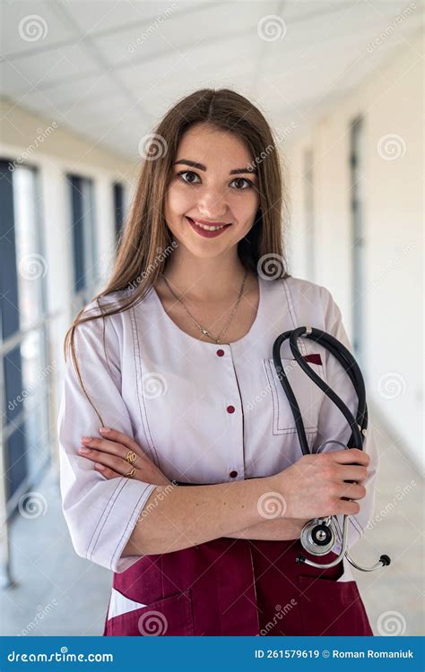 Smiling Female Doctor With Cute Friendly Appearance In Scrubs