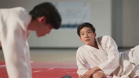 Two Men In White Kimonos Are On The Ground And One Man Is Kneeling Down