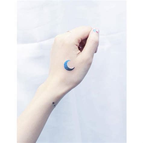 Blue spectrum moon tattoo on the left hand.