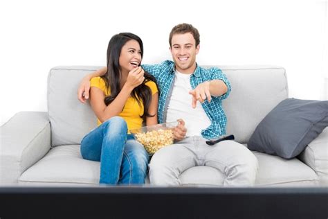 Premium Photo Couple Eating Popcorn While Watching Tv On Sofa