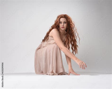Full Length Portrait Of Beautiful Brunette Model Wearing A Pink Dress Graceful Sitting Pose