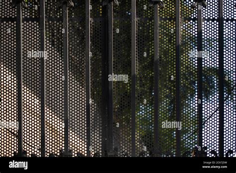 Black mesh patterned metallic fence Stock Photo - Alamy