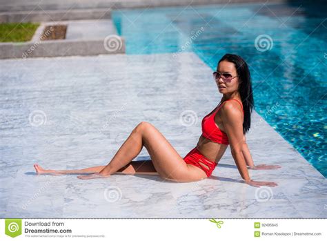 Elegant Woman In The Red Bikini On The Sun Tanned Slim And Shapely Body