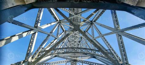 Photo of a structure of steel girders of a bridge in front of a blue ...