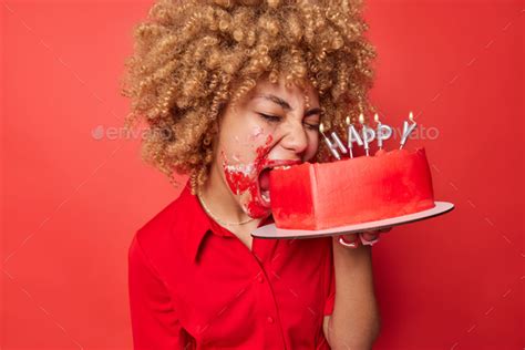 Upset Blonde Curly Haired Woman Bites Hungrily Delicious Sweet Cake Smeared With Cake Celebrates