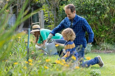 Caucasiano Pai E Filho No Jardim Regando Plantas E Jardinagem Sua