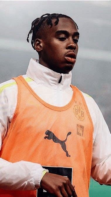 A Man In An Orange Vest Holding A Book