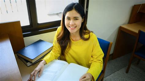 Beautiful Asian Female Student Reading Book Doing Class Assignment In