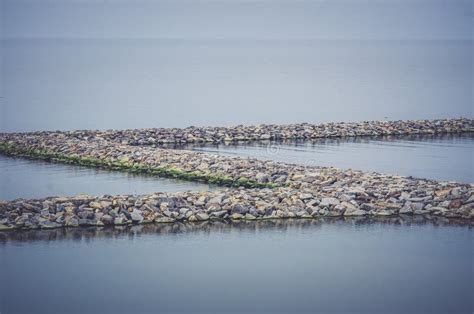 The Breakwater In The Form Of A Strip Of Stones Stretches Out Into The