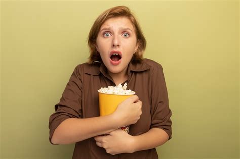 Jeune Fille Blonde Inquiète étreignant Un Seau De Pop corn Et Isolée