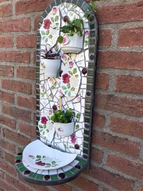 A Wall Mounted Planter On The Side Of A Brick Building With Flowers In It