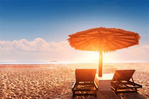 Premium Photo Two Chairs Under An Umbrella On A Beach