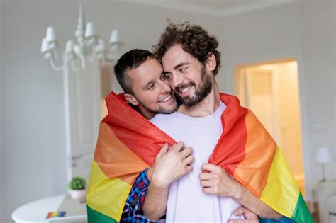 Cariñosa pareja gay masculina adentro hombre abrazando a su novio por detrás en casa pareja gay