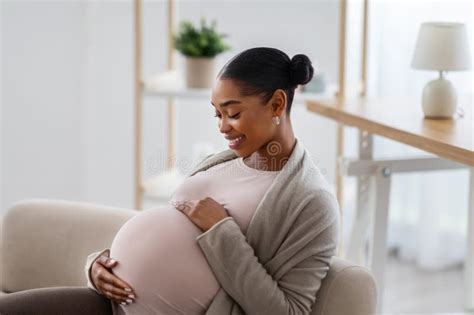 Side View Of African American Expecting Woman Touching Her Big Belly