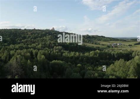 Aerial View Of A Lush Landscape With Rolling Hills Under A Bright Blue