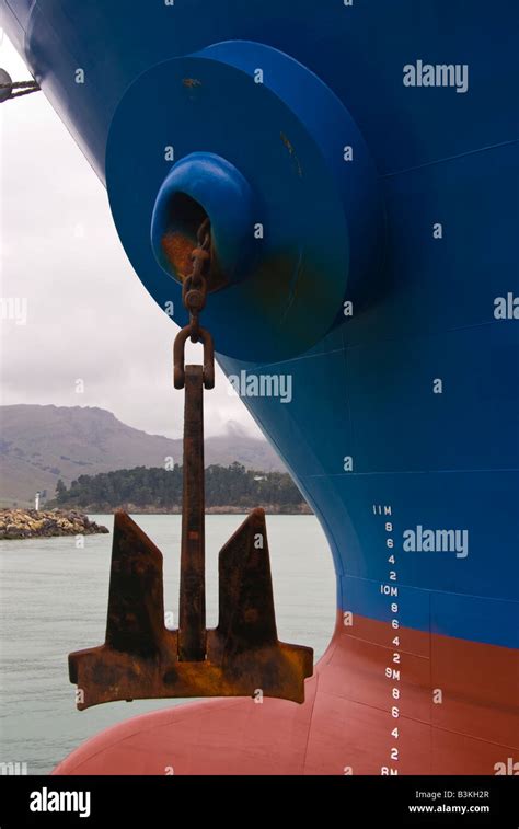 An Anchor Hangs From The Hawse Pipe At The Bow Of A Ship In Port