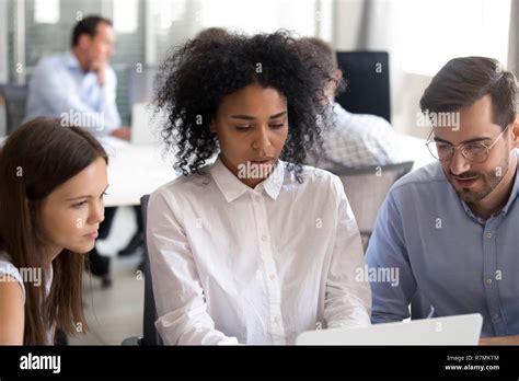 Office Workers With African American Female Leader Using Laptop Stock