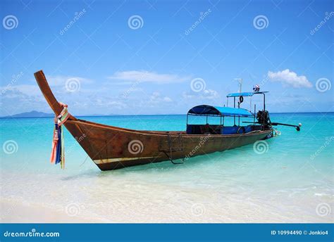 Thai Longtail Boat In The Sea At Sunset With Big Red Sun And Mountains