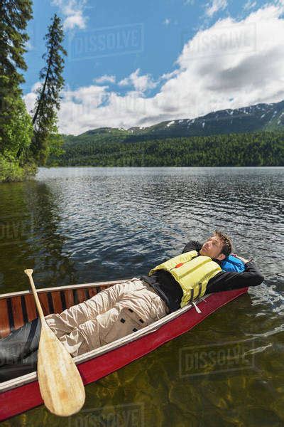 Man Reclined In Canoe And Resting In The Sunshine On Byers Lake With